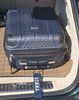 Blue suitcase with a U.S. Merchant Marine Academy tag inside a vehicle.